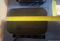 Front view of one speaker with tape measure showing width