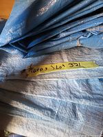 Close-up of folded blue tarp with masking tape label