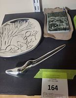 Plate, stone plaque, letter opener on shelf