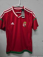 Front view of Adidas Hungary red soccer jersey on hanger
