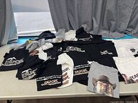 Spread of folded Duck Commander / Duck Dynasty T-shirts on table