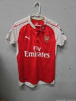 Front view of Puma Arsenal jersey on hanger showing overall design