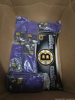 Box view of six purple Adidas socks/headbands and Boston Bruins sign