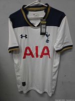 Front view of full jersey on hanger showing logos, sponsor, tags