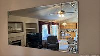 Front view of entire mirror on wall showing shape, beveled edges, and corner ornaments