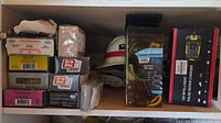 Shelf containing screw boxes, charger box, strap pack and hard hat