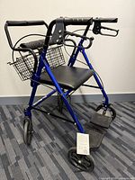 Front angled view showing blue frame, seat, basket, hand brakes, footrests