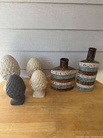 Full lot: two patterned ceramic vases, five pine-cone finials