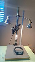Full view of Model 23C lamp on base with both lamp heads and included headband magnifier