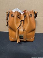 Front view of pumpkin pebble-grain leather Kendall bag with drawstring and tassels