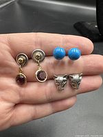 All three pairs of earrings side by side in hand