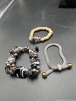 Group shot of the three bracelets on black surface
