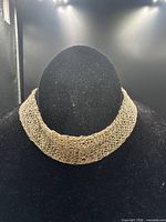 Full view of gold-tone crochet mesh collar necklace on display bust