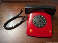 Full view of red FUTURFONE telephone with black handset and coiled cord