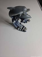 Front view of dolphin figurine showing two dolphins over wave