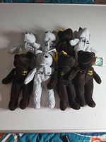 Group shot of all eight plush bears showing colors, embroidery, tags
