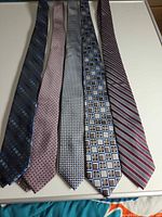 five silk neckties laid flat showing overall patterns and colors