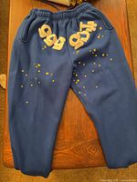 Full view of blue sweatpants showing front, graphics, waistband and cuffs