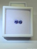 Pair of violet-blue round gemstones in white display box