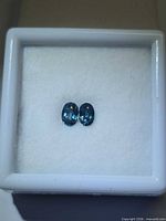 Pair of blue zircons in display box, top view