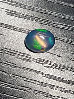 Front view of oval cabochon opal showing play-of-colour