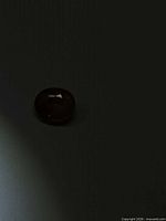 Oval mandarin peach zircon under dim lighting