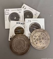 Six coins including four cash coins in flips and two larger silver-tone coins