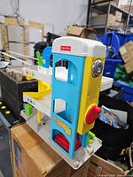 Front view showing Fisher-Price logo, elevator tower, open door arches, red gate
