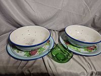Full set: two ceramic colander bowls on matching plates with green glass dish
