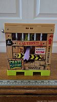 Front view of sealed crate showing Sizzle’s purple tongue and crate graphics