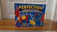 Front of Perfection board game box showing graphics and contents