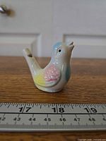 Front view of ceramic bird whistle with ruler for scale