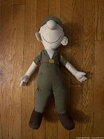 Front view of Beetle Bailey plush doll on wood floor