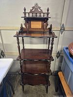Full view of etagere front showing five shelves and decorative top