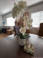 Artificial white orchid in textured white pot and Otagiri rabbit figurine on table