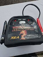 Front view of MotoMaster Eliminator jump starter showing controls, clamps and branding