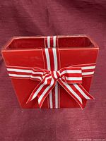 Front view of red ceramic planter showing ribbon bow