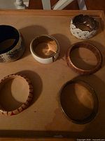 Six bracelets on tray showing variety of materials and designs