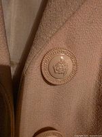 Front close-up showing Medusa button and fabric texture