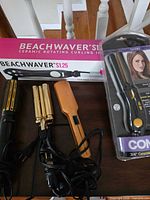 All five hair tools displayed: Beachwaver box, Conair packaging, loose hot air brush, triple-barrel waver, Avanti flat iron