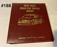 Closed burgundy binder with gold lettering and stock car image