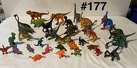 Group shot of all 32 plastic dinosaur figures arranged on white backdrop