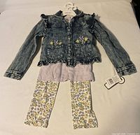 Full outfit laid out showing denim jacket, top hem and leggings