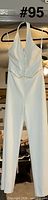 Full front view of white halter jumpsuit on hanger