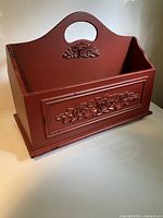 Front view showing carved floral panel and handle