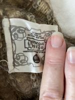 Close-up of Donegal Design scarf label showing brand and material
