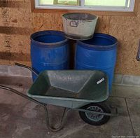 Wheelbarrow, two of the blue barrels and galvanized basin in context