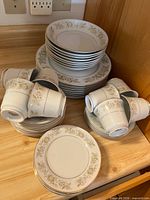 Overall view of stacked dinner plates, bread plates and teacups
