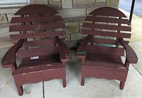 Two brown wooden Adirondack-style chairs side by side