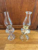 Both glass hurricane lamps side by side